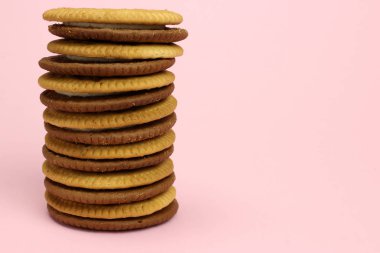 Pembe arka planda kakaolu kurabiye sandviçi.