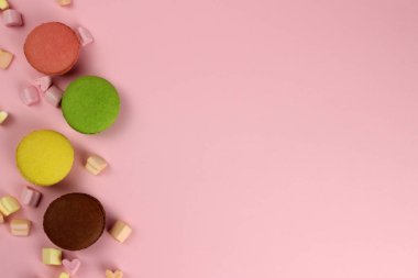 Pembe arkaplandaki renkli badem kurabiyeleri ya da badem kurabiyeleri, metin alanınızı kopyalayın
