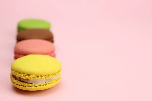 Colored macaroons or macarons on a pink background — 스톡 사진