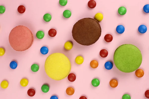 Renkli badem kurabiyeleri ya da pembe arka planda makaronlar, renkli şekerler. Arkaplan, doku — Stok fotoğraf