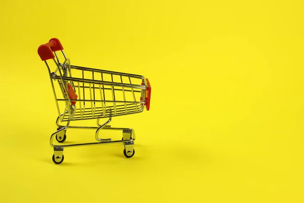 Mini carrinho de supermercado, carrinho com fundo amarelo. Compras — Fotografia de Stock