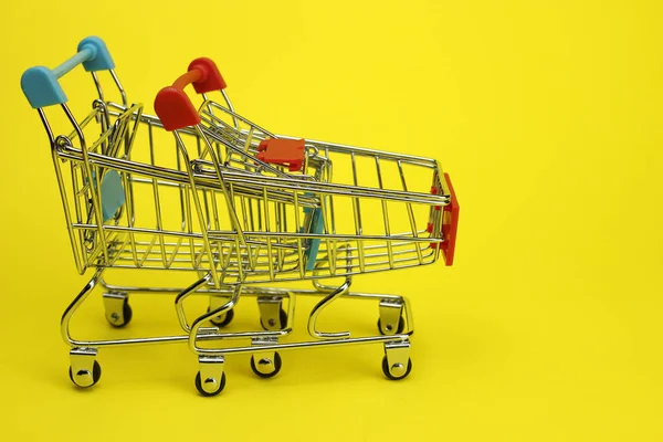 Folded mini supermarket Carts on a yellow background. The view from the top. Purchases