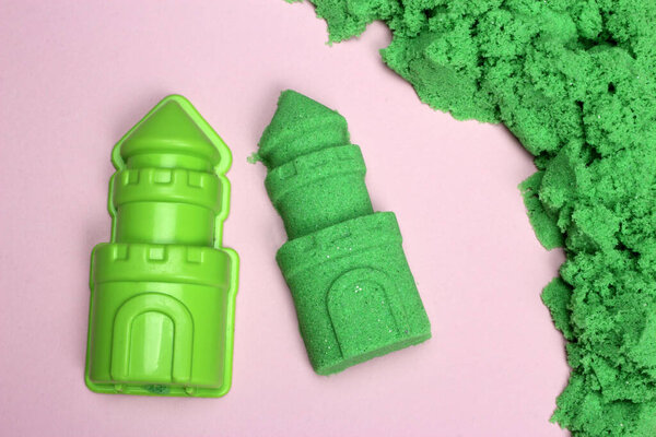 Green Kinetic sand. Mold and figure of the tower