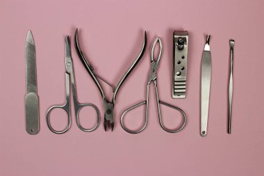 Pembe arka planda manikür ve pedikür araçları