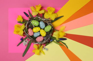Yuvada renkli Paskalya yumurtaları ve bahar çiçekleri, metin için yer