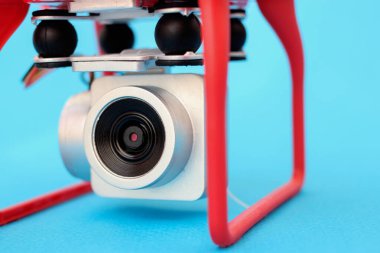 İHA 'nın kamerası, mavi arkaplana yakın plan bir kuadrokopter.