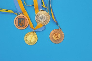 Mavi yüzeyde altın, gümüş ve bronz madalyalar. Ukrayna Madalyaları