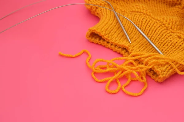 ニットウールセーターと編み物針上ピンクの背景 — ストック写真