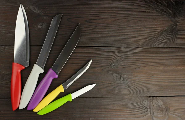 Set Coltelli Cucina Con Manici Colorati Uno Sfondo Legno Scuro — Foto Stock