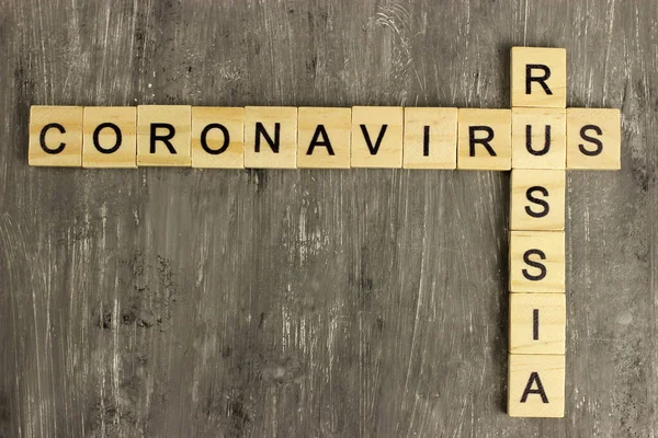 木製の文字からコロナウイルスとロシア語の単語のクロスワード 世界中で流行性感染症や医療健康リスクの概念が広まり — ストック写真