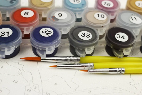 Paints and brushes for drawing pictures by numbers, copyspace