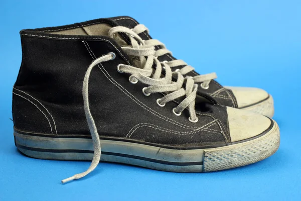 Sneakers Negro Viejo Desgastado Vintage Sobre Fondo Azul —  Fotos de Stock