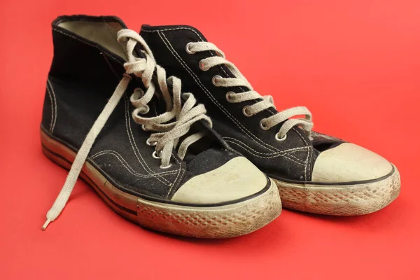Sneakers Negro Viejo Desgastado Vintage Sobre Fondo Rojo —  Fotos de Stock