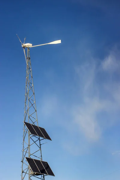 solar wind generator against a blue cloudy sky, alternative environmental energy