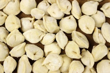 Ahşap bir tahtada etli ev yapımı çiğ hamur köftesi, pelmeni
