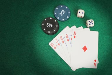 Kumarhane elementleri, çipler, kartlar yeşil bir keçeli masa üzerinde Royal floş kombinasyonu