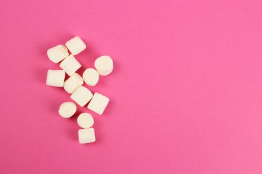 Pembe arkaplana dağılmış şekerlemeler.