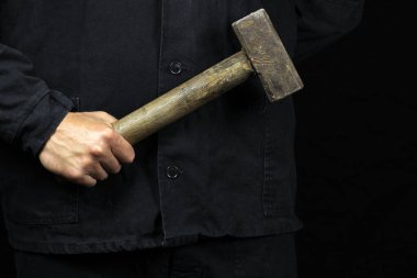 Balyoz, çekiç siyah arka planda bir işçinin elinde.