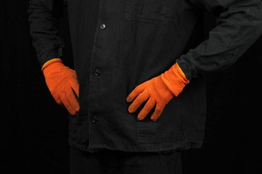 Siyah arka planda, özel üniformalı ve eldivenli bir işçi.