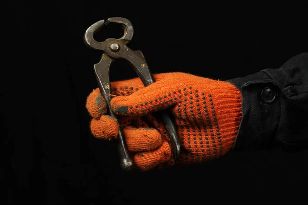 Ένα Χέρι Γάντια Κρατά Ένα Ζευγάρι Πένσες Μαύρο Φόντο Από — Φωτογραφία Αρχείου