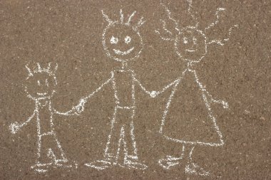 Çocuk tebeşiri asfalta mutlu bir aile çiziyor.