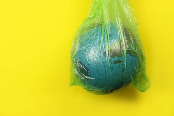 Globe in a plastic garbage bag. Concept of an environmental disaster on the planet. Copy space for your text