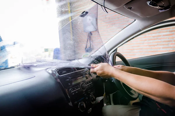 Mãos de homem removendo filme antigo janela do carro — Fotografia de Stock