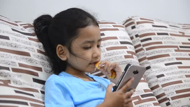Закрыть снимок маленькой девочки, использующей смартфон дома — стоковое видео