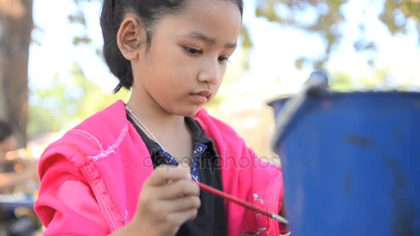 Крупним планом знімок азіатська дівчинка малює ляльку — стокове відео