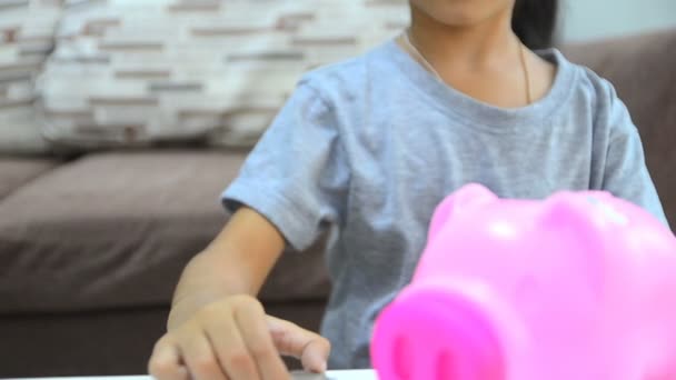 高清特写镜头亚洲小女孩把硬币放到存钱罐 — 图库视频影像