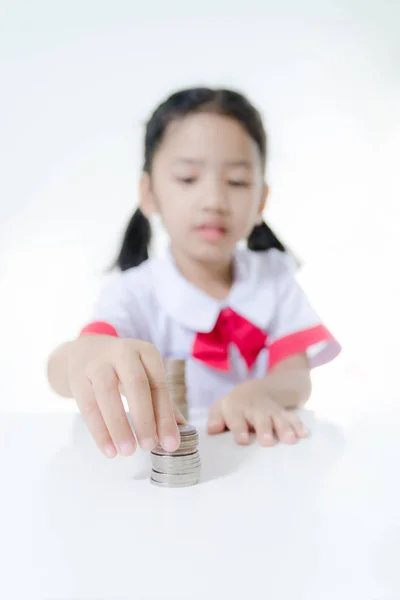 Asiática niña en tailandés estudiante uniforme apilamiento monedas — Foto de Stock