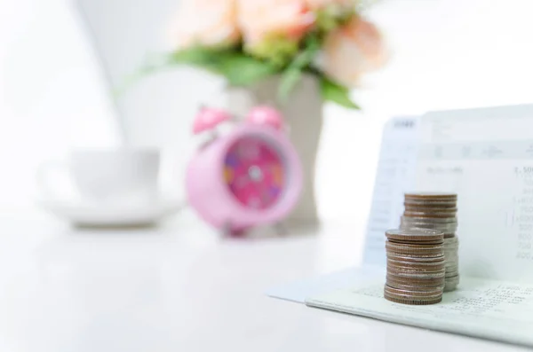 Stack of coins on saving bank accound book and alarm clock on th — Stock Photo, Image