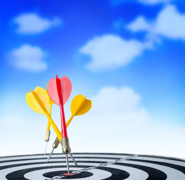 Close up shot red dart arrow on center of dartboard and yellow a — Stock Photo, Image