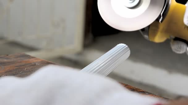 Gros plan Mains de l'homme utilisant une meuleuse électrique pour couper un tuyau en aluminium blanc — Video