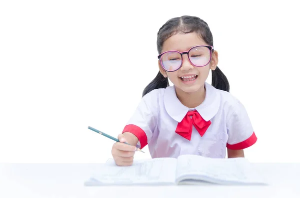 Азиатская девочка делает домашнее задание с улыбкой изолированы на белой ба — стоковое фото