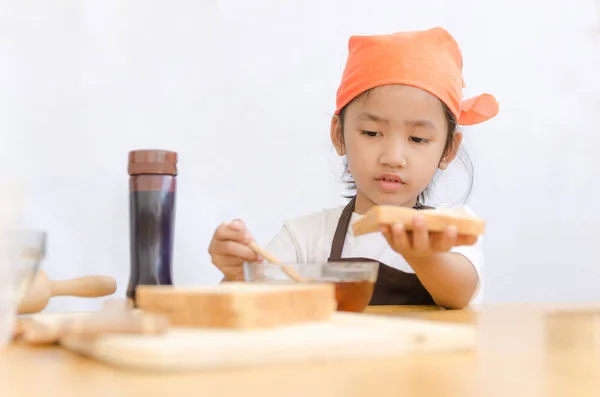 Asiatique petite fille tenir le pain et miel bâton de trempette sur blanc — Photo