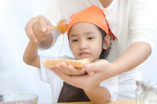 Asiatique petite fille tenir le pain et miel trempette bâton avec mot — Photo