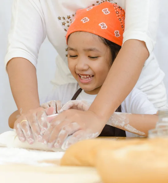 Primer plano de niña asiática con las manos de la madre amasando — Foto de Stock