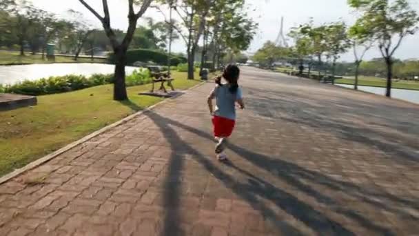 亚洲小女孩在相机从动件的公共公园跑步 — 图库视频影像