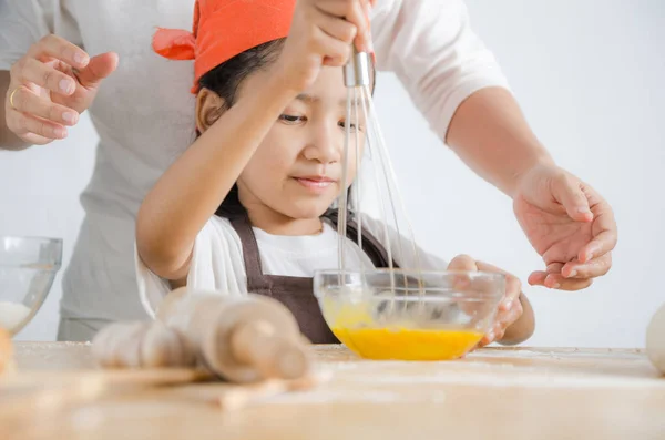 Asiatique petite fille à l'aide de fouet en acier inoxydable pour mélanger l'œuf pour — Photo