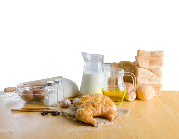 Produtos de padaria e ingredientes sobre mesa de madeira isolada em branco — Fotografia de Stock
