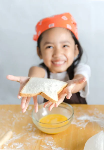 Asiatique petite fille montrant le pain — Photo