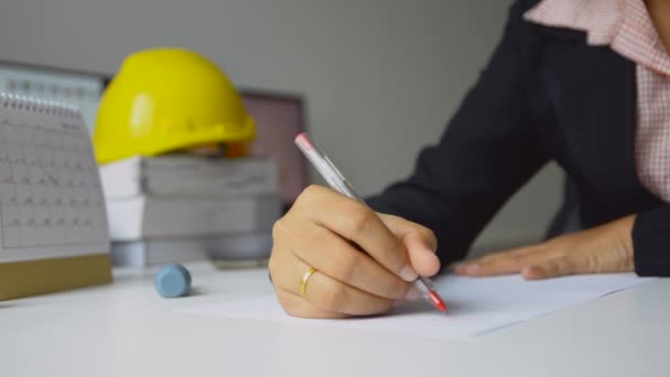 Крупным планом женщины-архитекторы используют красную ручку для рисования черновика на белой бумаге в офисе Небольшая глубина резкости — стоковое видео