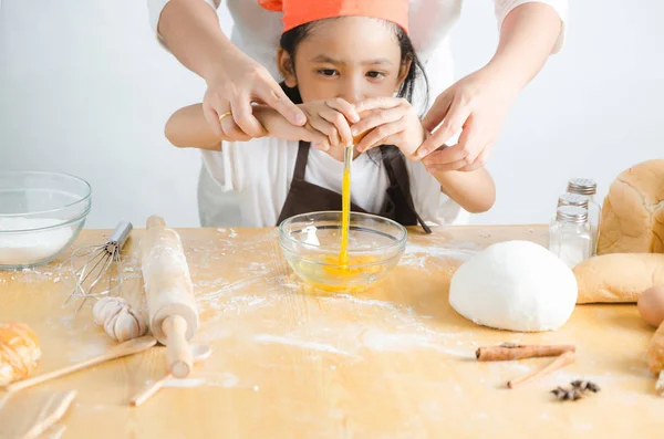 Asiatique petite fille rupture coquille d'oeuf pour faire de la boulangerie — Photo