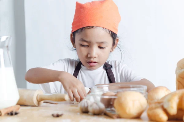 Retrato de niña asiática sosteniendo la masa en la mano y panadería o — Foto de Stock