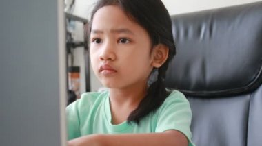 Dizüstü bilgisayar kullanan Asyalı küçük kız görüntüsünü kapatmak