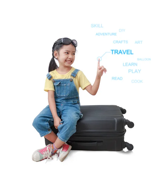 Lächeln asiatisches kleines Mädchen sitzt auf dem Gepäck und zeigt auf die — Stockfoto