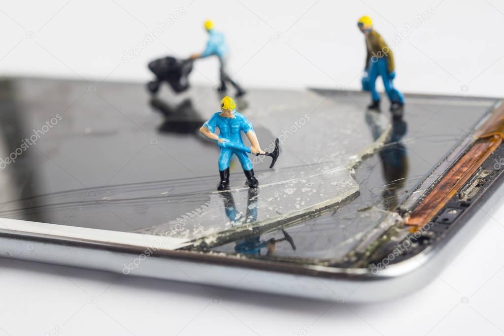 The miniature man fixing broken smartphone