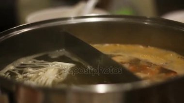 Kadının shot el yakından beyaz mantar güveç koyarak yemek çubukları kullanın