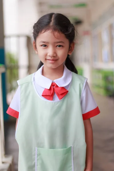 Asyalı küçük kız Tay öğrenci üniforma smilin içinde anaokulunda — Stok fotoğraf